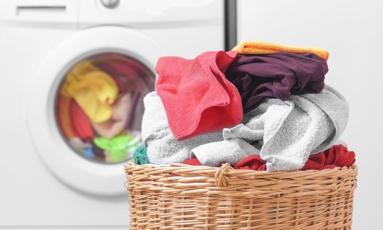 Basket full of laundry with washing machine in the background