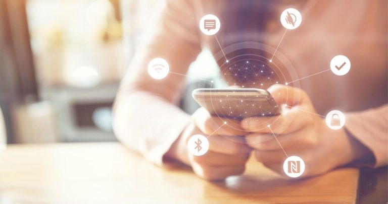 Woman holding smartphone with icons radiating out from the device. Icons show symbols for bluetooth, messaging app, WayAround, and more