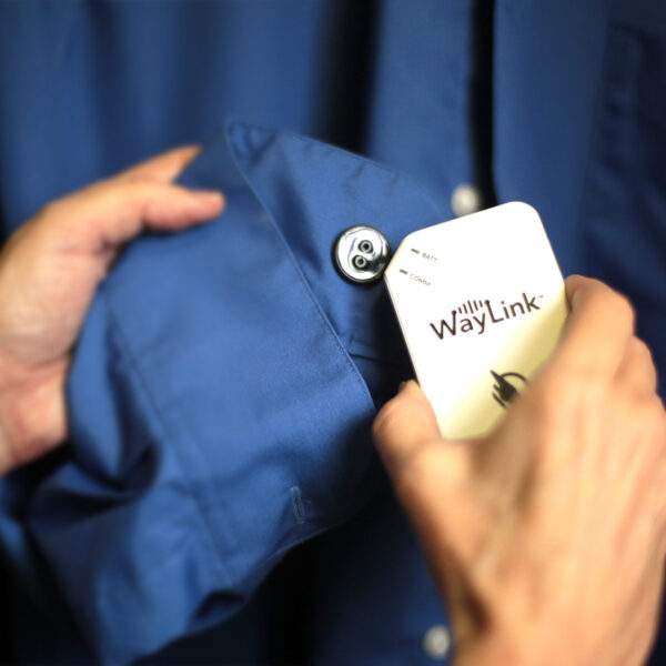 WayTag button sewn to the inside of a shirt sleeve being scanned using a WayLink device